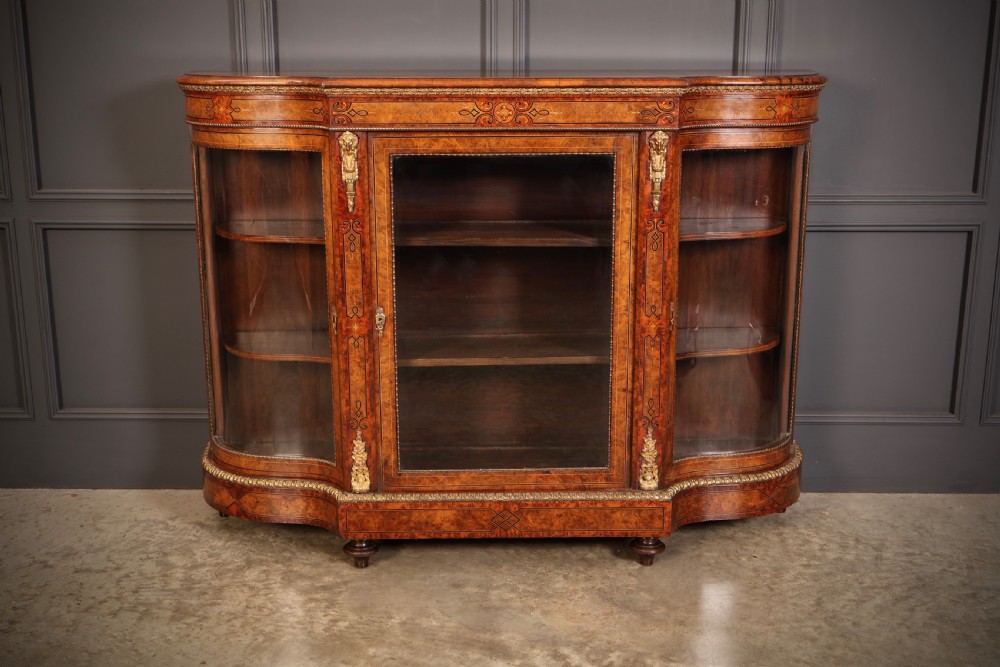 A Victorian burr walnut credenza with intricate marquetry inlay, gilt bronze mounts, and glazed display sections.