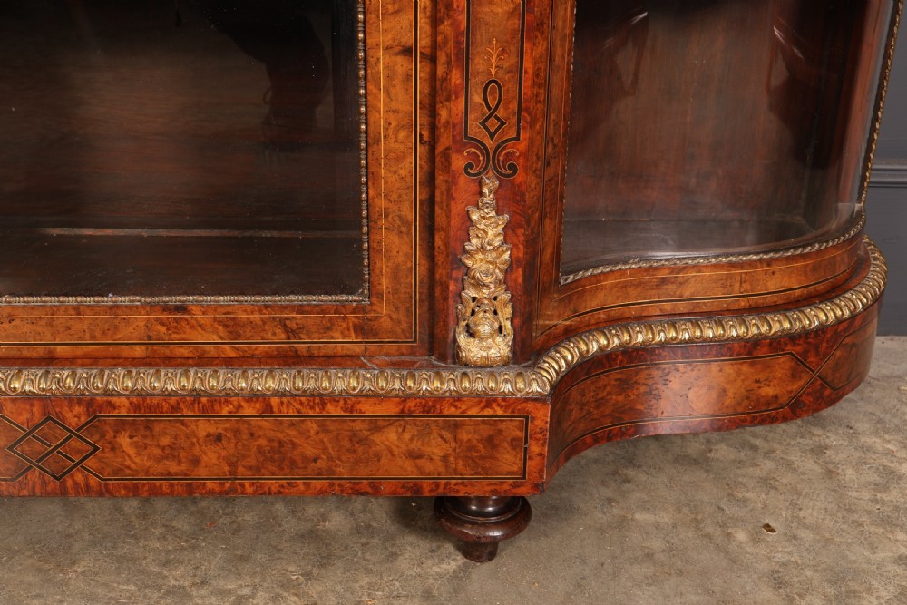 A Victorian burr walnut credenza with intricate marquetry inlay, gilt bronze mounts, and glazed display sections. View VI