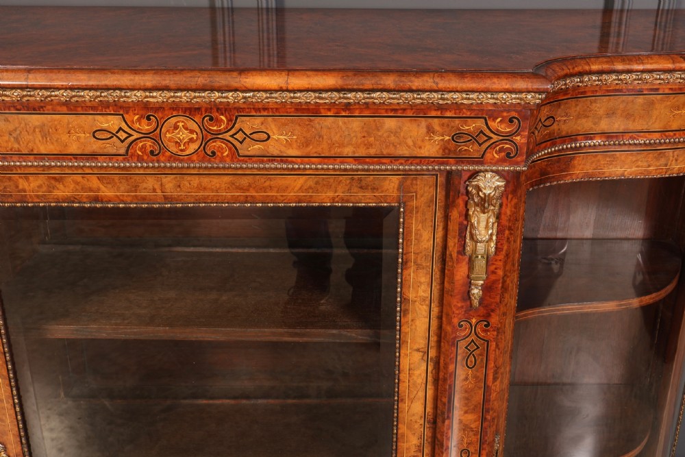 A Victorian burr walnut credenza with intricate marquetry inlay, gilt bronze mounts, and glazed display sections. View VII