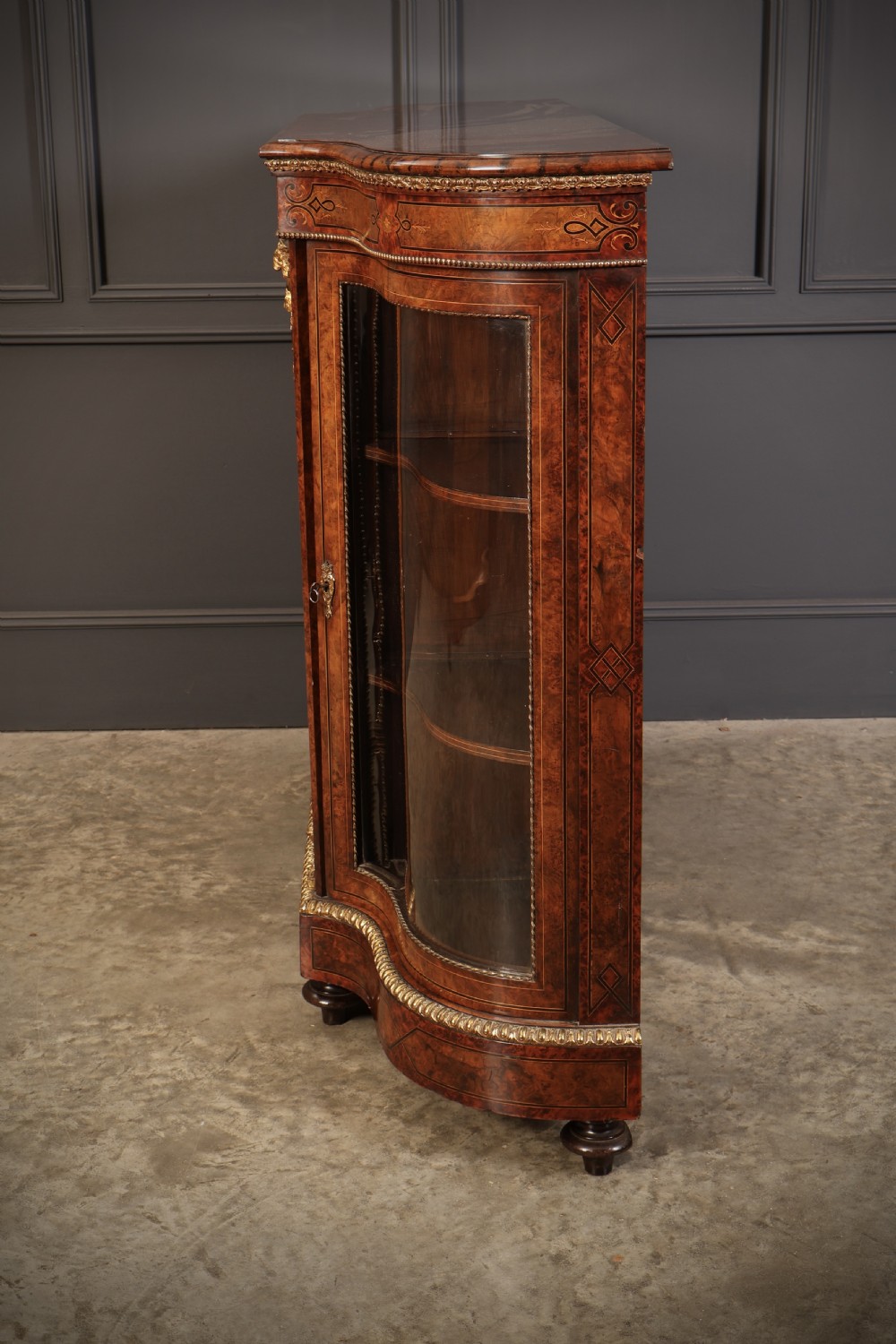 A Victorian burr walnut credenza with intricate marquetry inlay, gilt bronze mounts, and glazed display sections. View XV