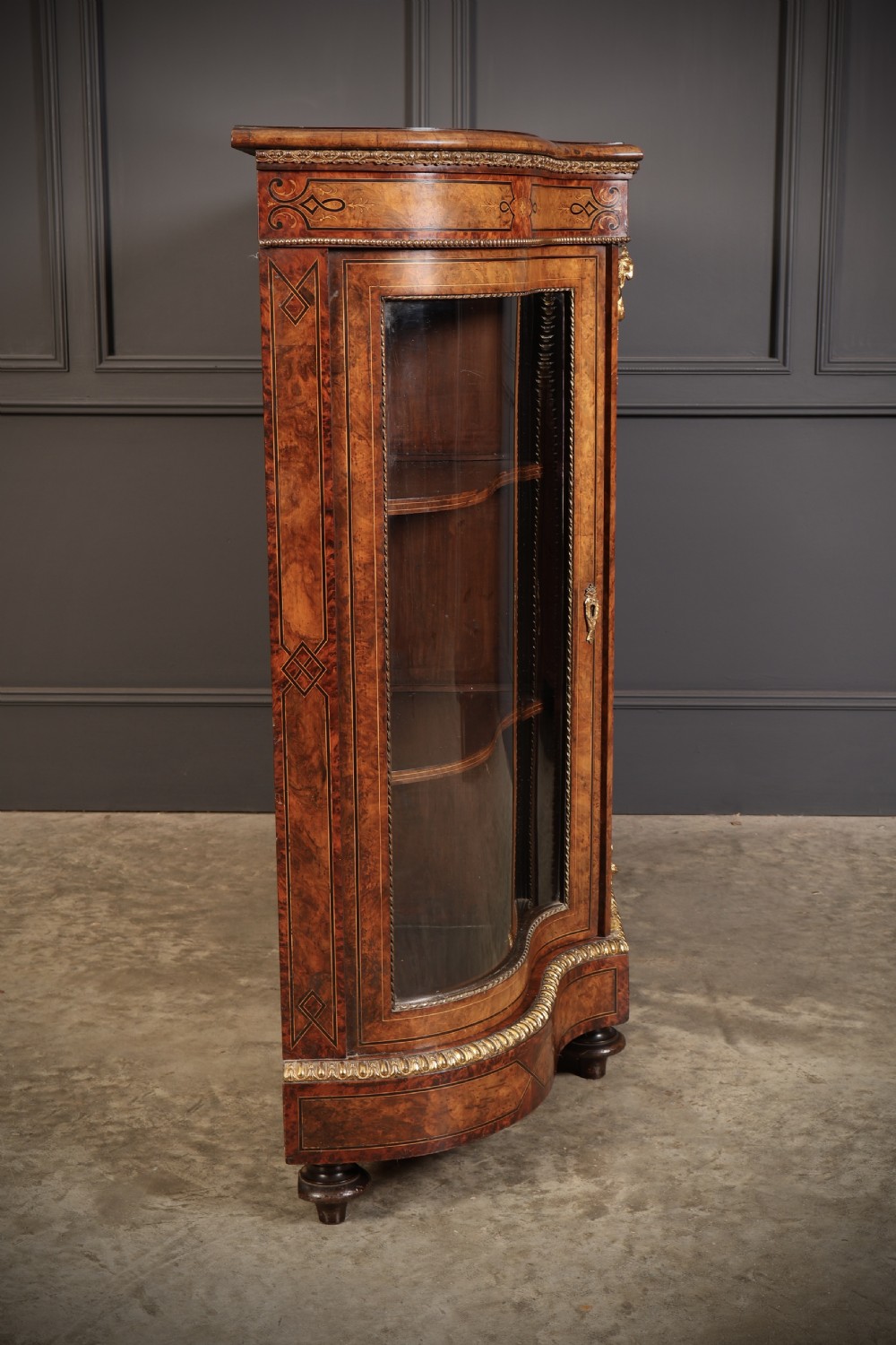 A Victorian burr walnut credenza with intricate marquetry inlay, gilt bronze mounts, and glazed display sections. View XVIII