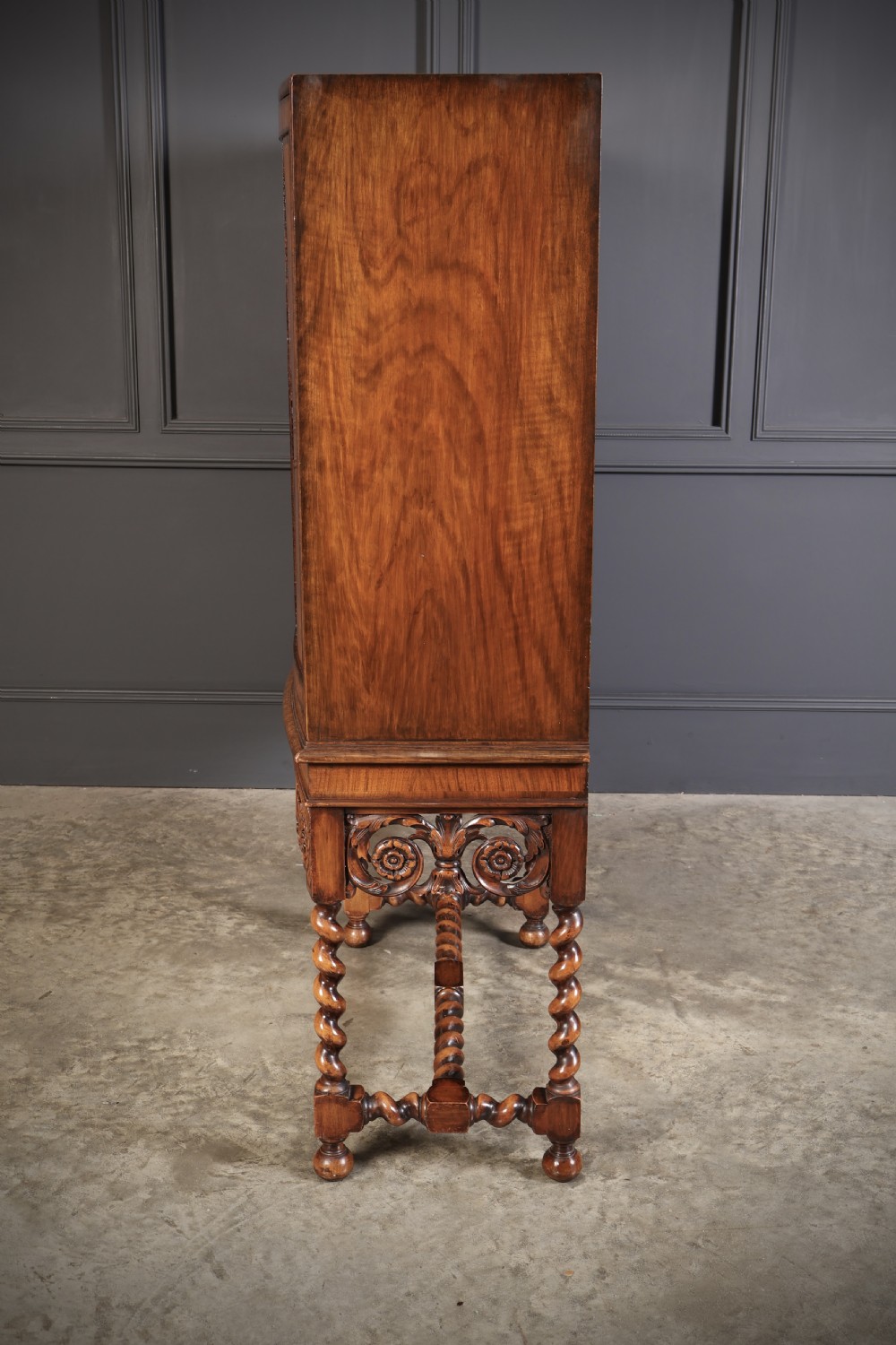 A double bow-front burr walnut cocktail cabinet featuring carved scrollwork on the lower apron, supported by six barley twist legs joined by stretchers. View XII