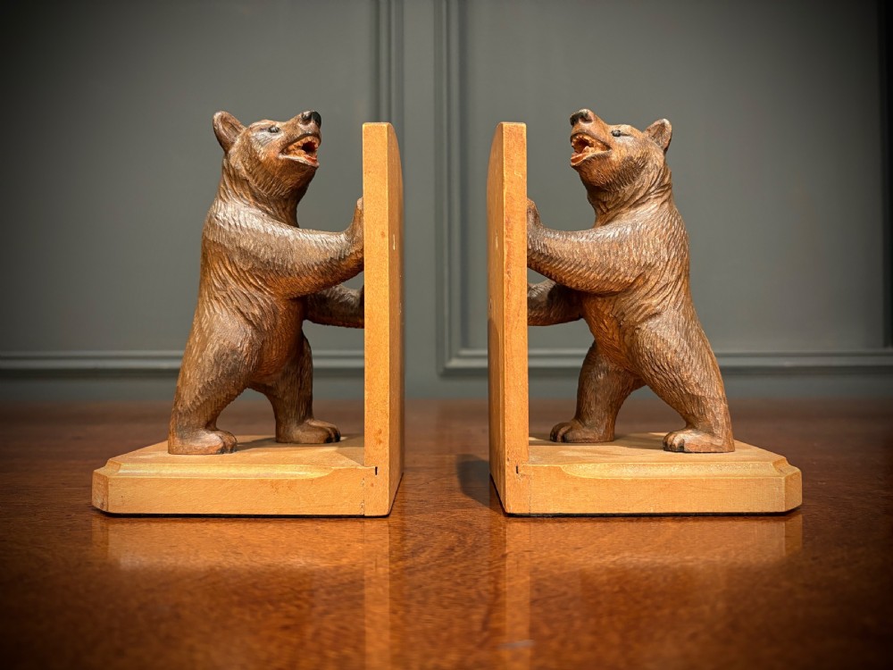 A pair of hand-carved wooden bookends depicting standing bears with open mouths pushing against vertical wooden supports. View II