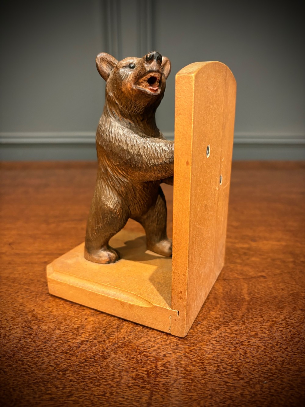 A pair of hand-carved wooden bookends depicting standing bears with open mouths pushing against vertical wooden supports. View IV