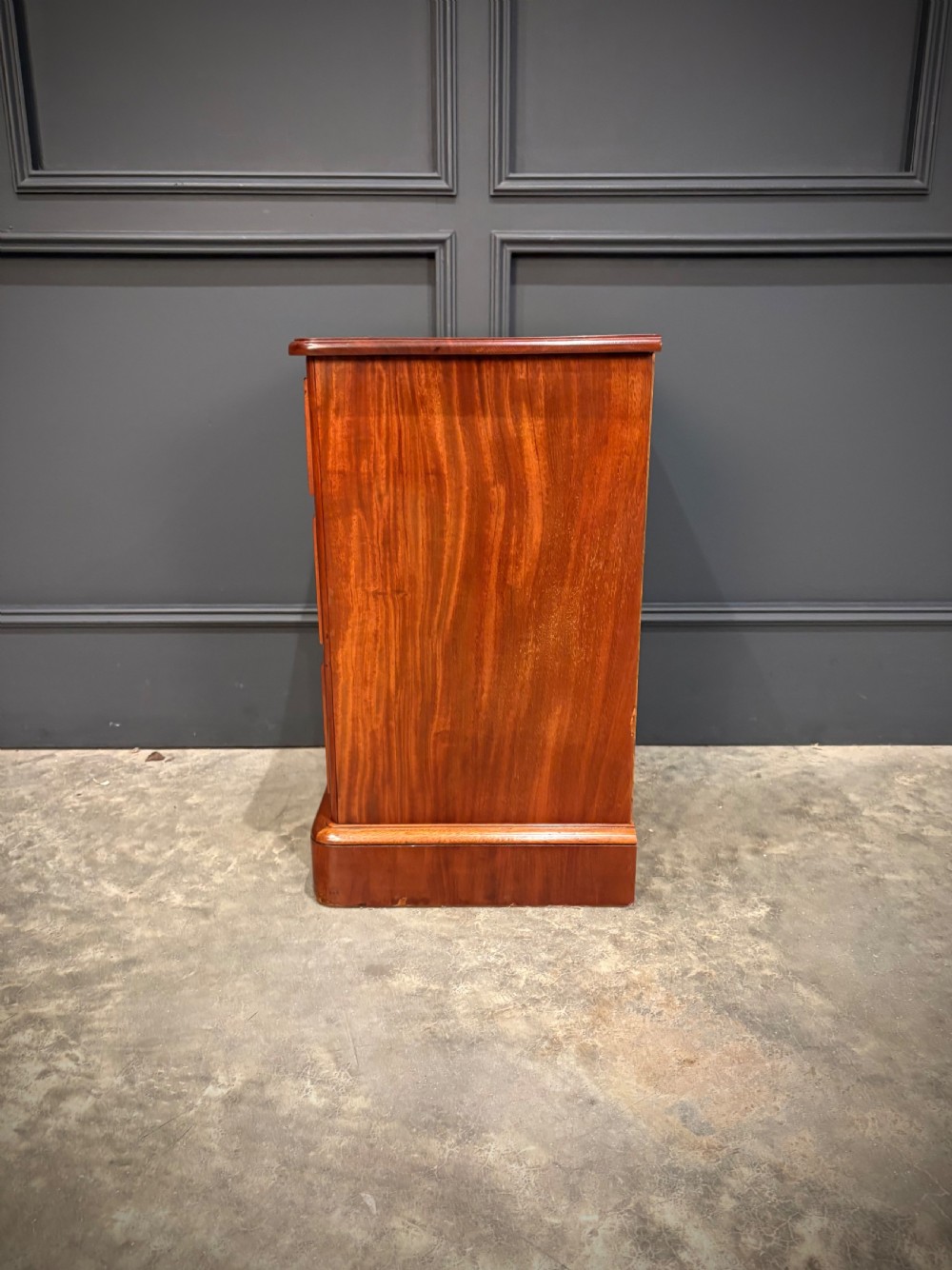 A pair of Victorian mahogany bedside chests, each featuring three drawers with brass drop ring handles on a solid plinth base. View XI