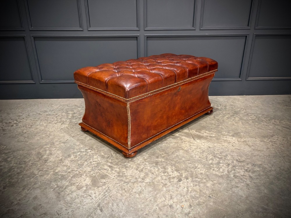 A large Regency style chestnut brown leather storage ottoman featuring deep diamond button tufting and brass stud trim on a shaped base. View II