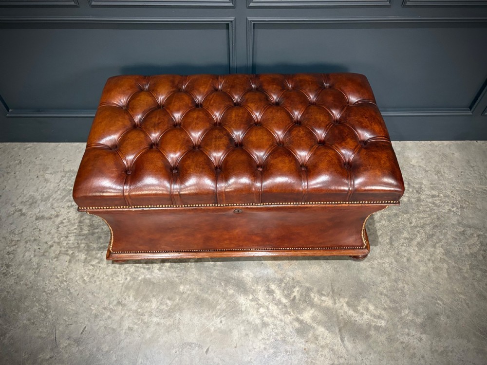 A large Regency style chestnut brown leather storage ottoman featuring deep diamond button tufting and brass stud trim on a shaped base. View XII