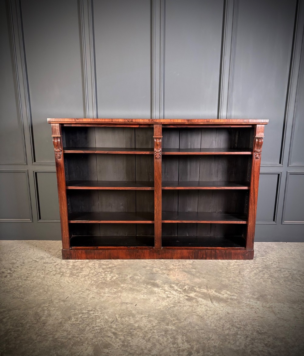 A low Victorian open bookcase made from dark rosewood with two bays of adjustable shelves and carved corbels. View III