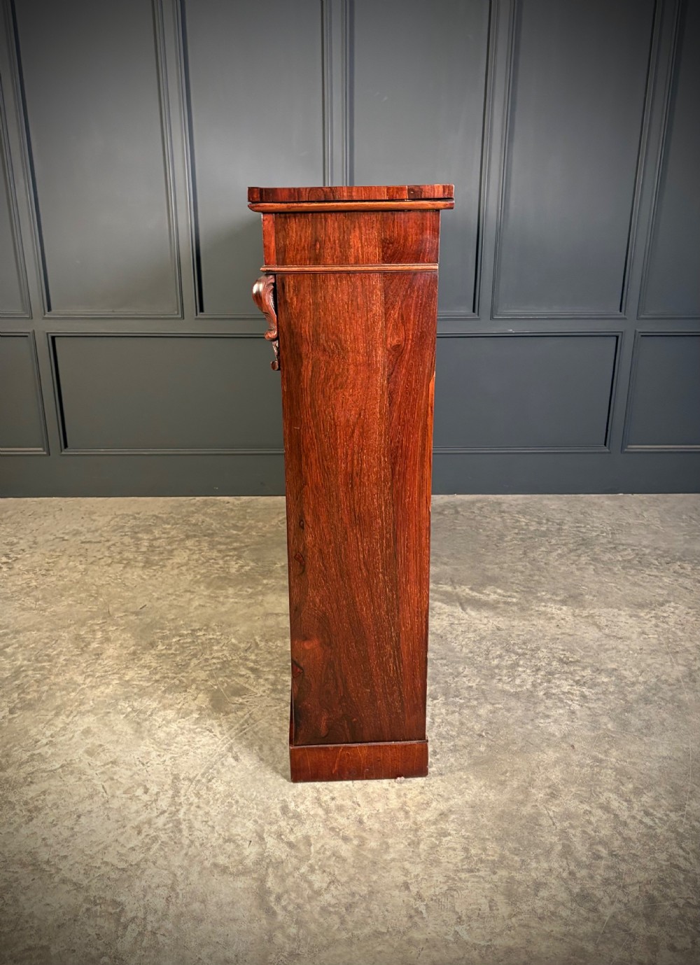 A low Victorian open bookcase made from dark rosewood with two bays of adjustable shelves and carved corbels. View VII