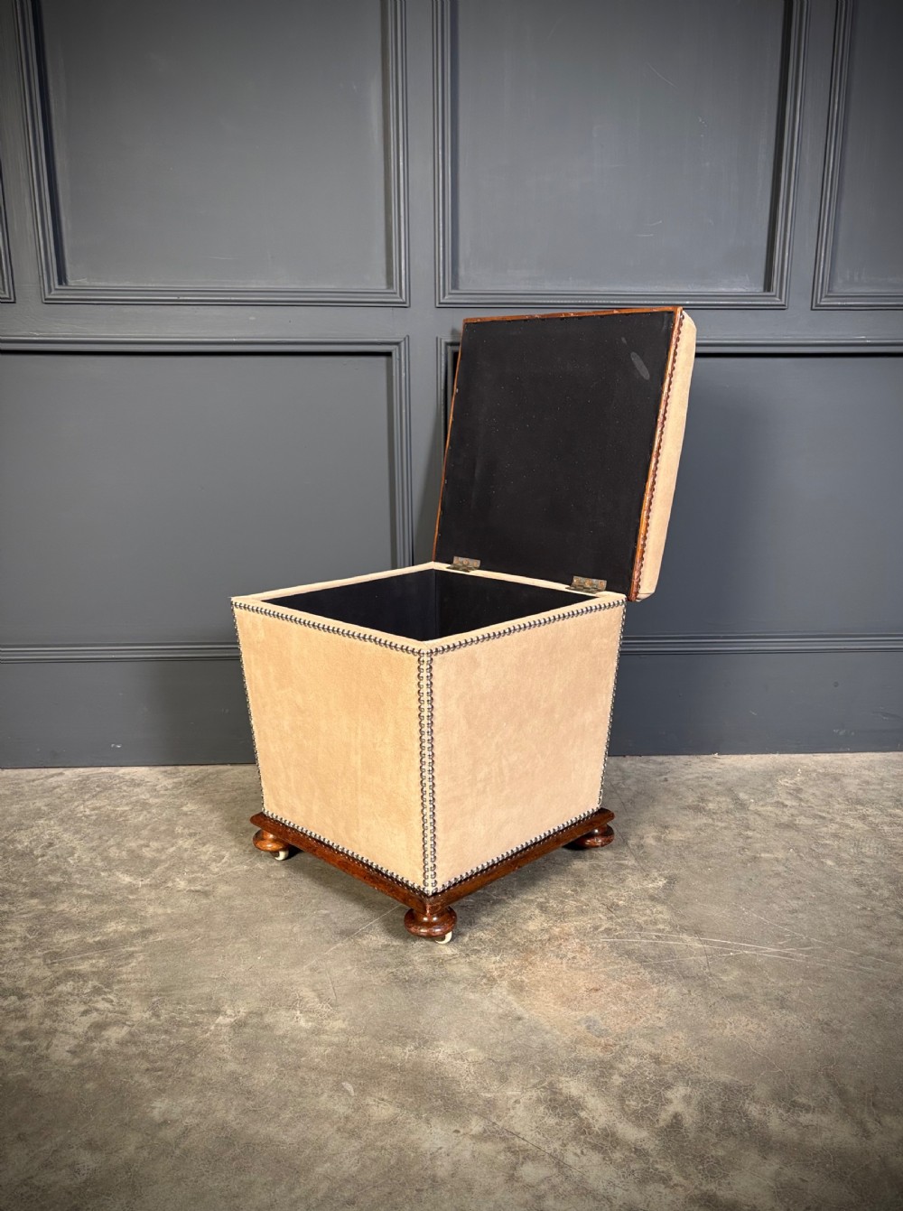 A pair of square Regency style ottomans upholstered in beige fabric with brass stud trimming, raised on short mahogany legs with castors. View VIII