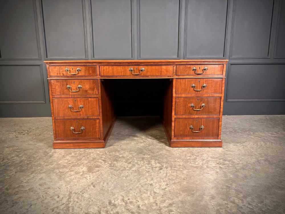 A large Victorian walnut partners desk featuring a green leather inset top, dual pedestals with multiple drawers, and brass handles. View IX