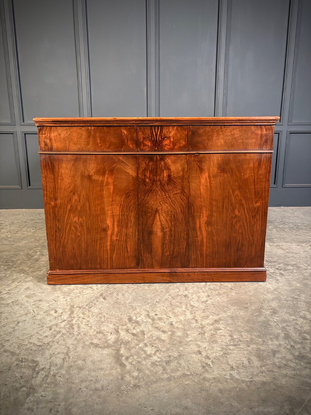A large Victorian walnut partners desk featuring a green leather inset top, dual pedestals with multiple drawers, and brass handles. View X