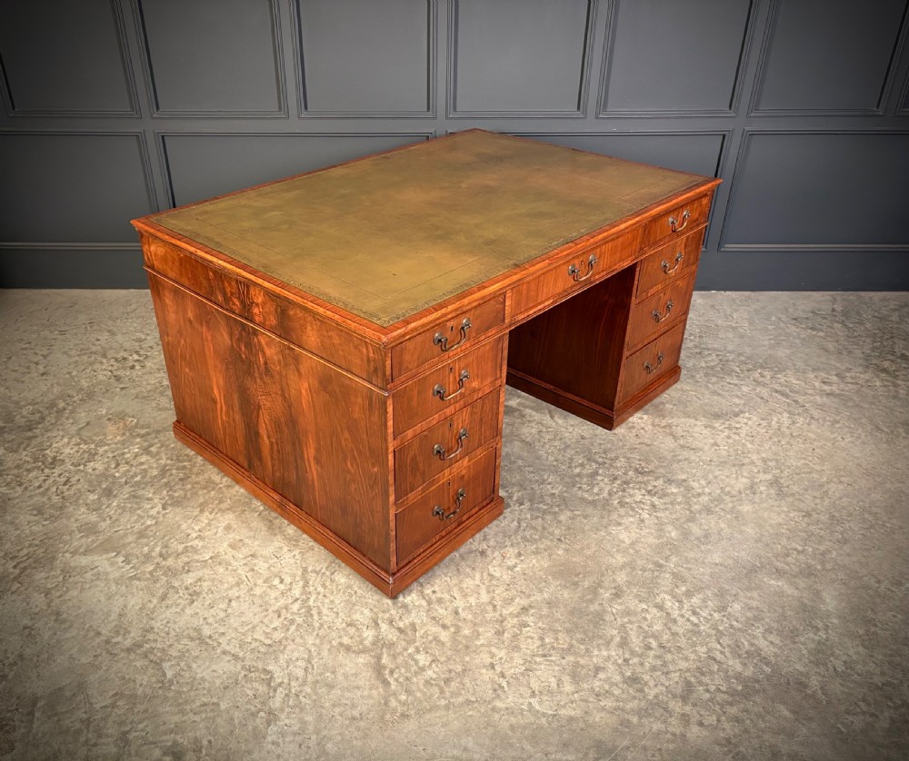 A large Victorian walnut partners desk featuring a green leather inset top, dual pedestals with multiple drawers, and brass handles. View II