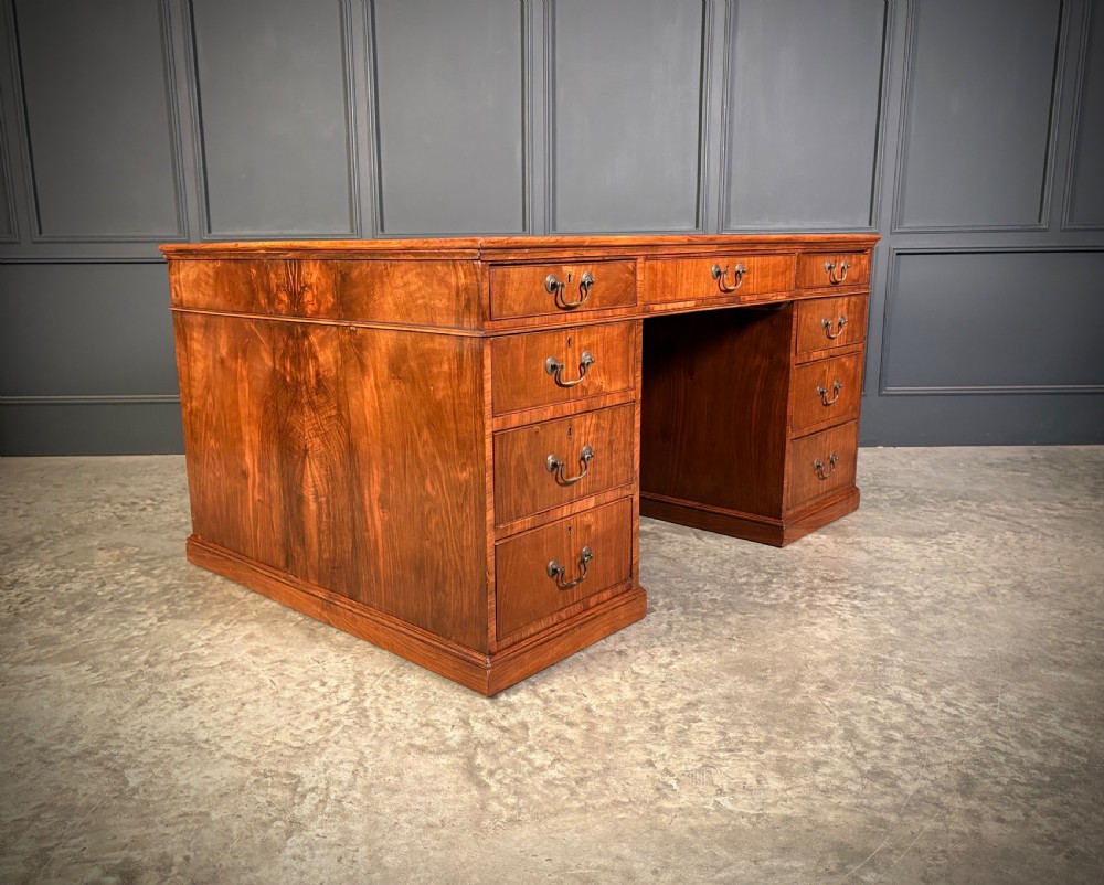 A large Victorian walnut partners desk featuring a green leather inset top, dual pedestals with multiple drawers, and brass handles. View XIII