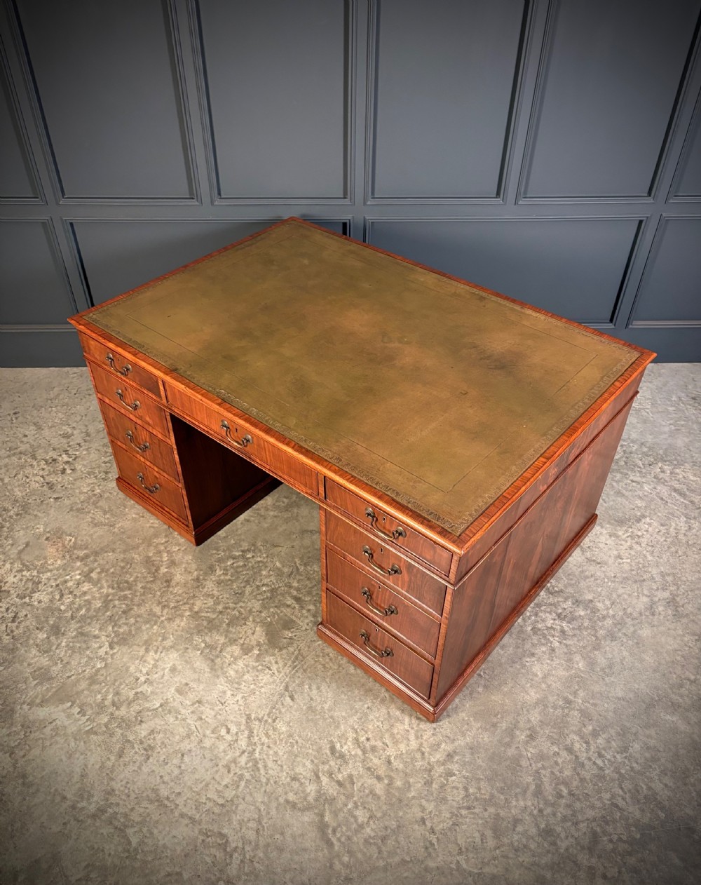 A large Victorian walnut partners desk featuring a green leather inset top, dual pedestals with multiple drawers, and brass handles. View XVIII