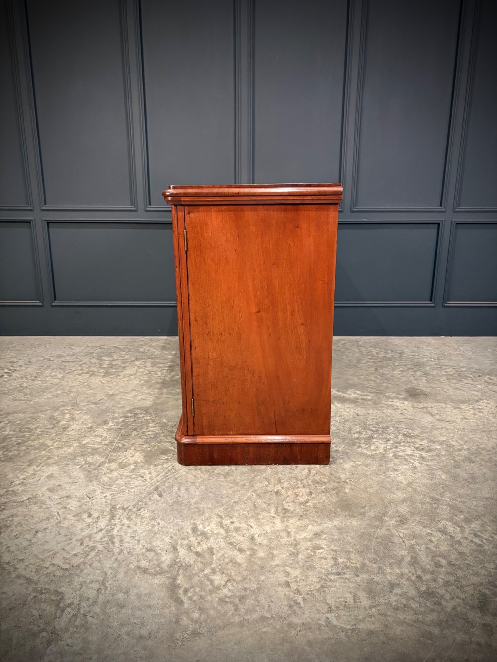 A Victorian mahogany three-door sideboard featuring flame mahogany panelled cupboard doors and a central top drawer on a solid plinth base. View XIII