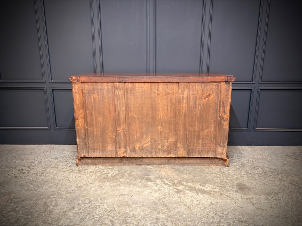 A Victorian mahogany three-door sideboard featuring flame mahogany panelled cupboard doors and a central top drawer on a solid plinth base. View XIV