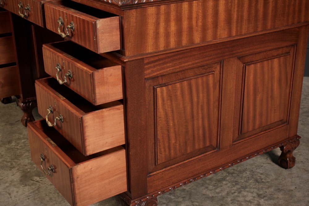 A mahogany pedestal desk with a brown leather inset writing surface, swan-neck brass handles, and carved claw and ball feet. View VIII