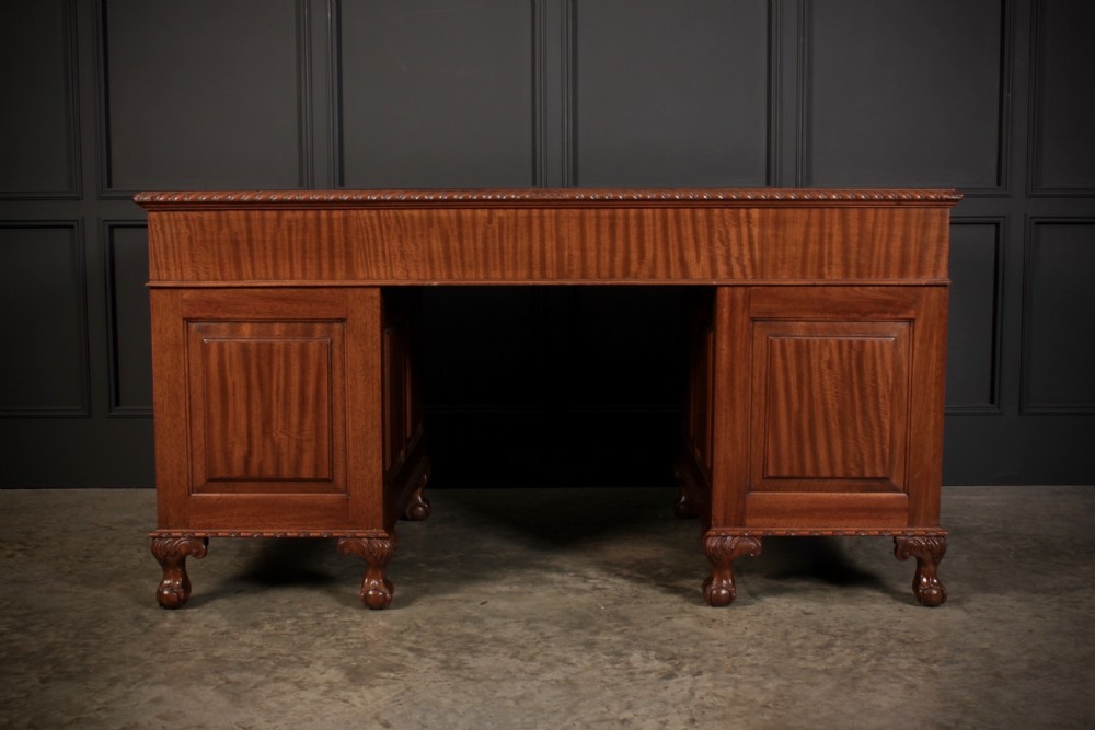 A mahogany pedestal desk with a brown leather inset writing surface, swan-neck brass handles, and carved claw and ball feet. View XII