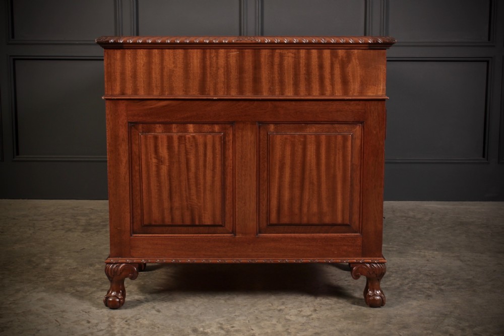 A mahogany pedestal desk with a brown leather inset writing surface, swan-neck brass handles, and carved claw and ball feet. View XIII