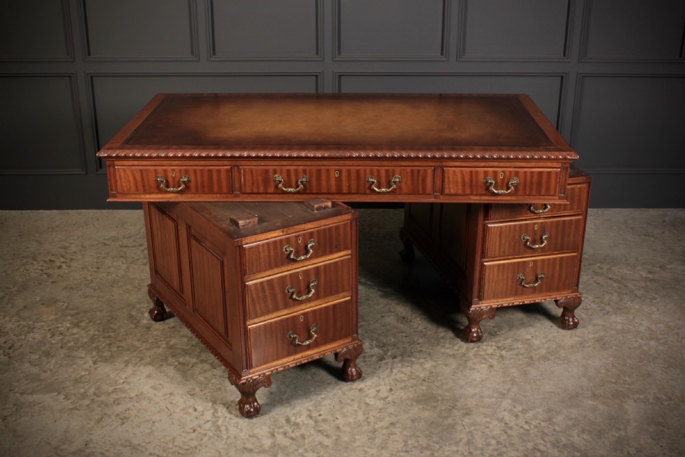 A mahogany pedestal desk with a brown leather inset writing surface, swan-neck brass handles, and carved claw and ball feet. View XIV