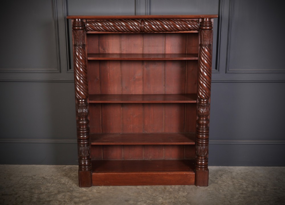 A William IV dark mahogany open bookcase featuring four shelves flanked by spiral twist carved columns and a detailed frieze. View IV