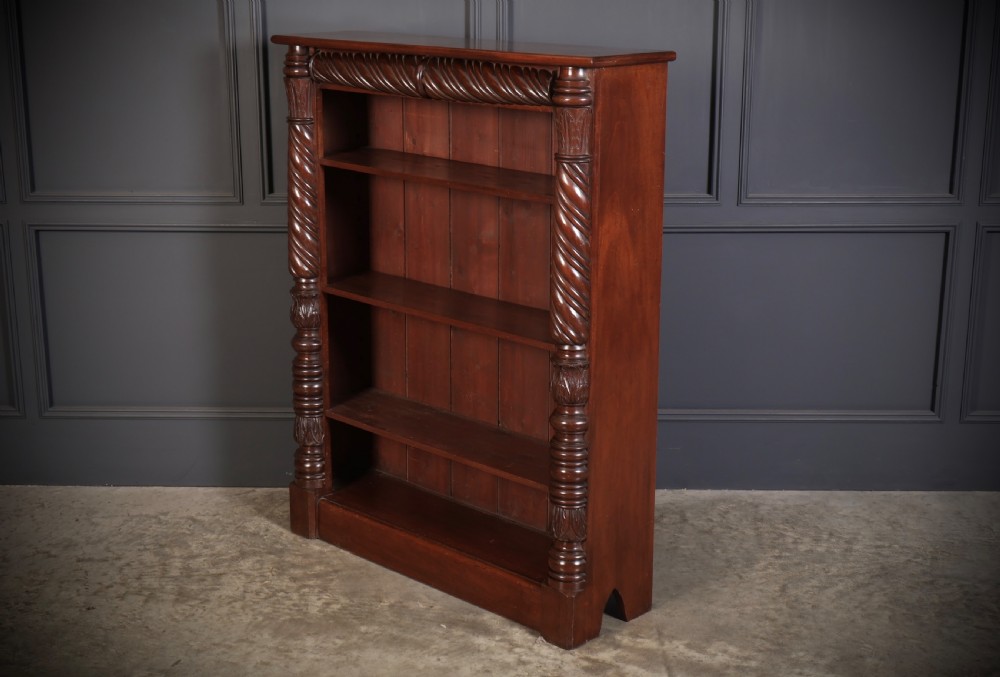 A William IV dark mahogany open bookcase featuring four shelves flanked by spiral twist carved columns and a detailed frieze. View V