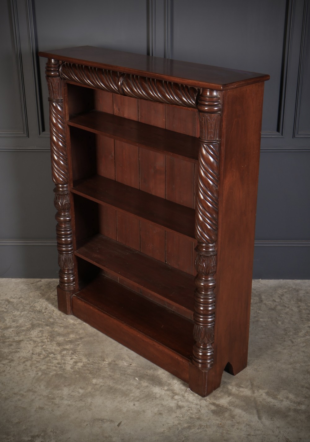 A William IV dark mahogany open bookcase featuring four shelves flanked by spiral twist carved columns and a detailed frieze. View VI