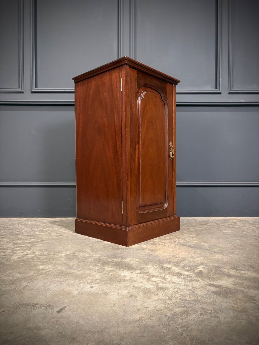 A pair of antique rich mahogany bedside cabinets featuring single arched panel doors and solid plinth bases. View VI