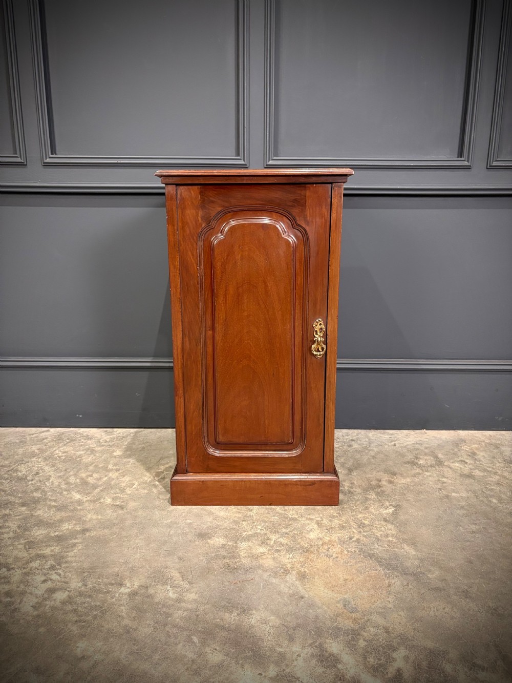 A pair of antique rich mahogany bedside cabinets featuring single arched panel doors and solid plinth bases. View VII