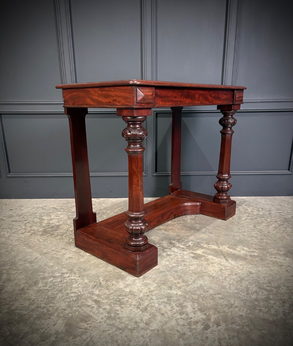 An antique dark mahogany console table featuring carved turned columns and a solid plinth base. View II