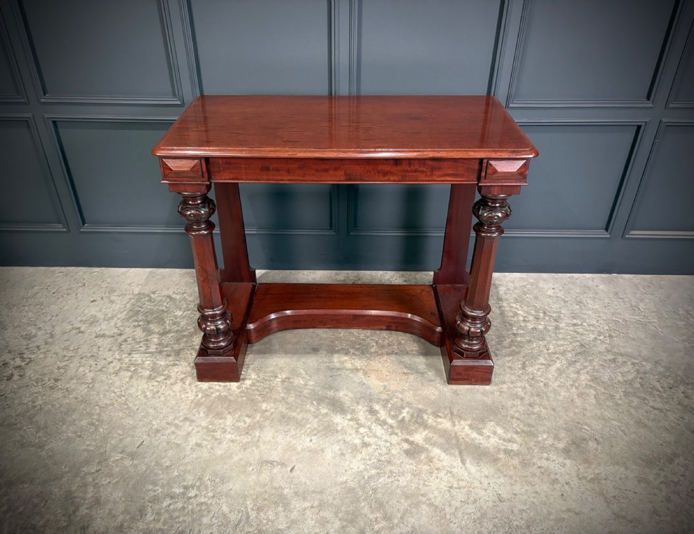 An antique dark mahogany console table featuring carved turned columns and a solid plinth base. View VI