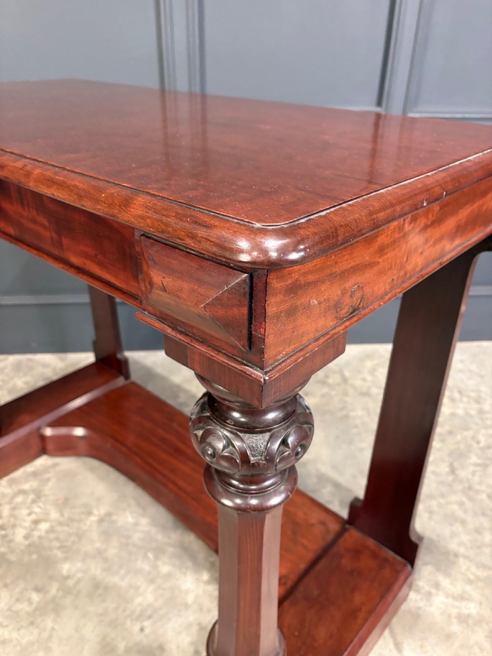 An antique dark mahogany console table featuring carved turned columns and a solid plinth base. View X