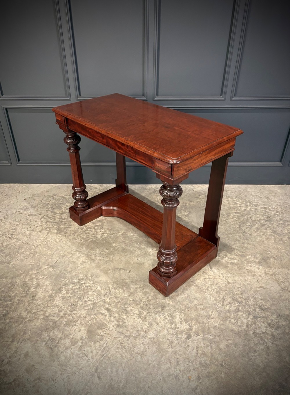 An antique dark mahogany console table featuring carved turned columns and a solid plinth base. View XI