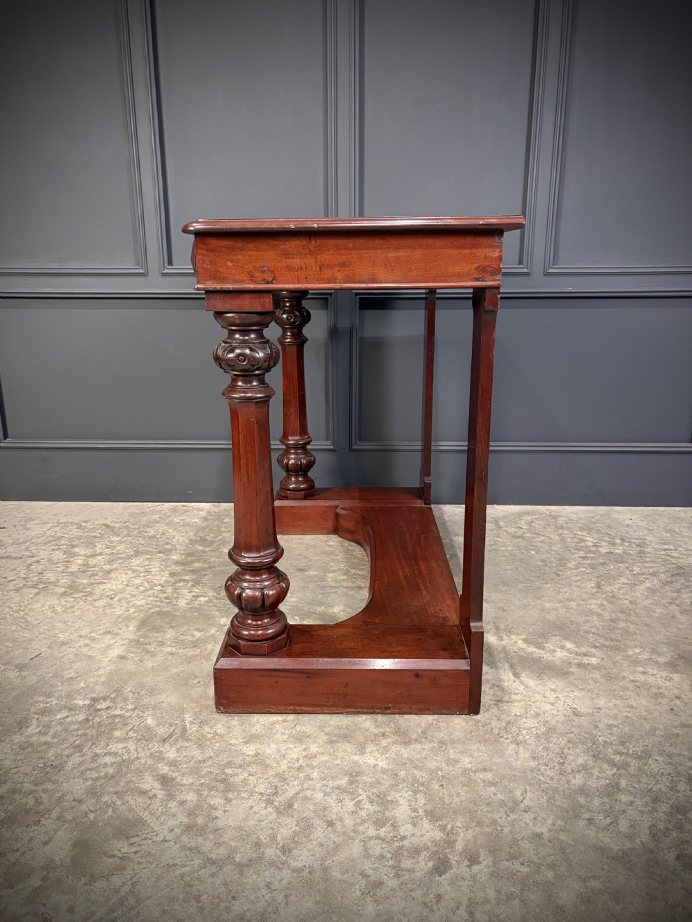 An antique dark mahogany console table featuring carved turned columns and a solid plinth base. View XII