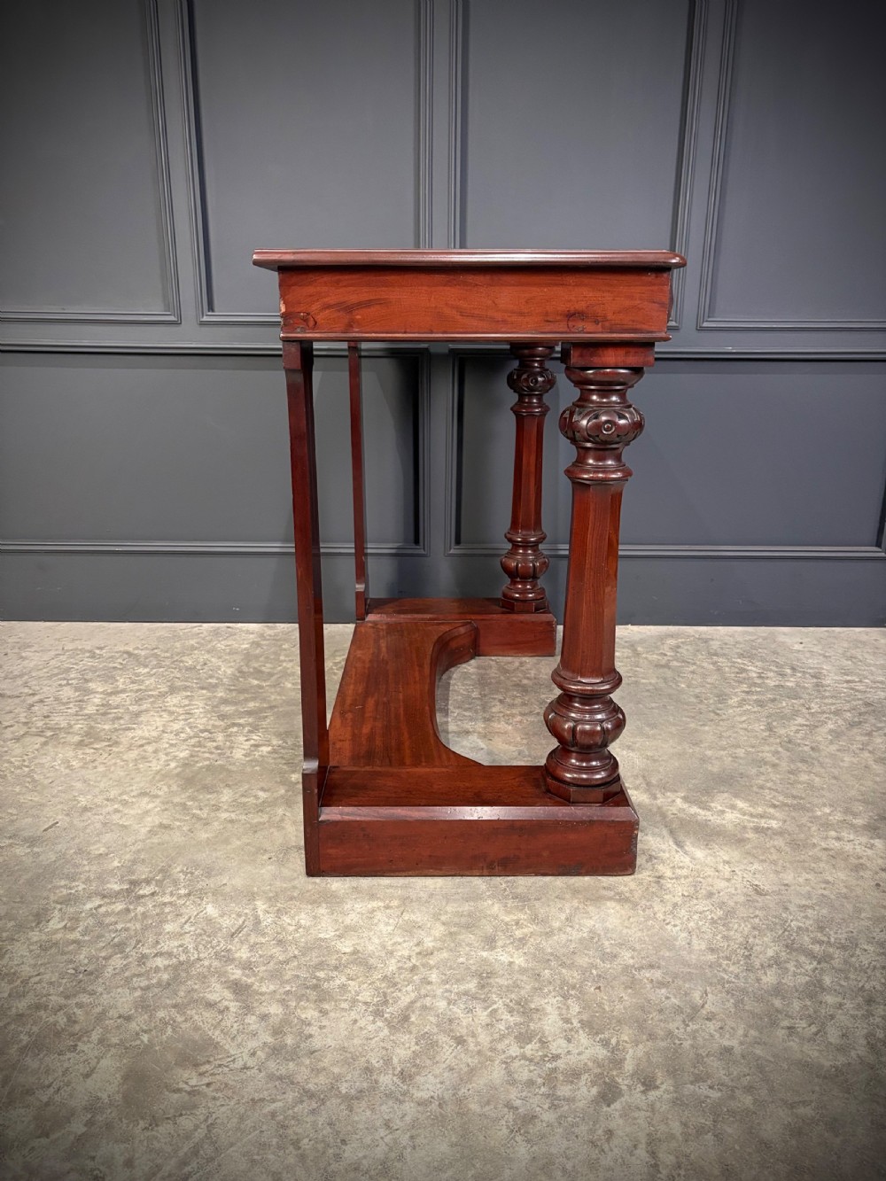 An antique dark mahogany console table featuring carved turned columns and a solid plinth base. View XIV