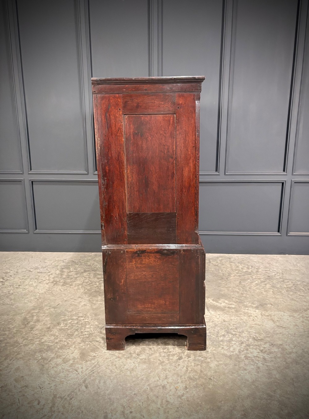 An 18th-century dwarf oak housekeepers cupboard featuring twin doors with pointed arch fielded panels over a base of five drawers. View VIII