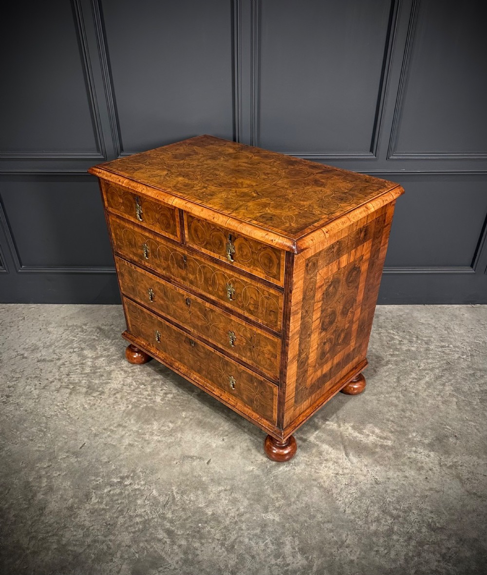 A William and Mary period walnut chest of drawers featuring geometric oyster veneering, brass teardrop handles, and turned bun feet. View IX