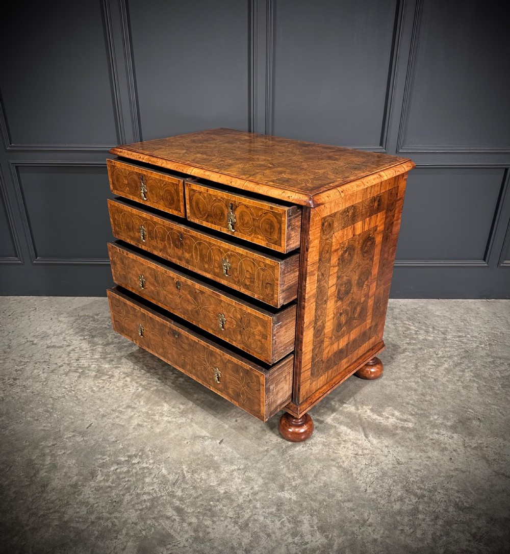 A William and Mary period walnut chest of drawers featuring geometric oyster veneering, brass teardrop handles, and turned bun feet. View XII