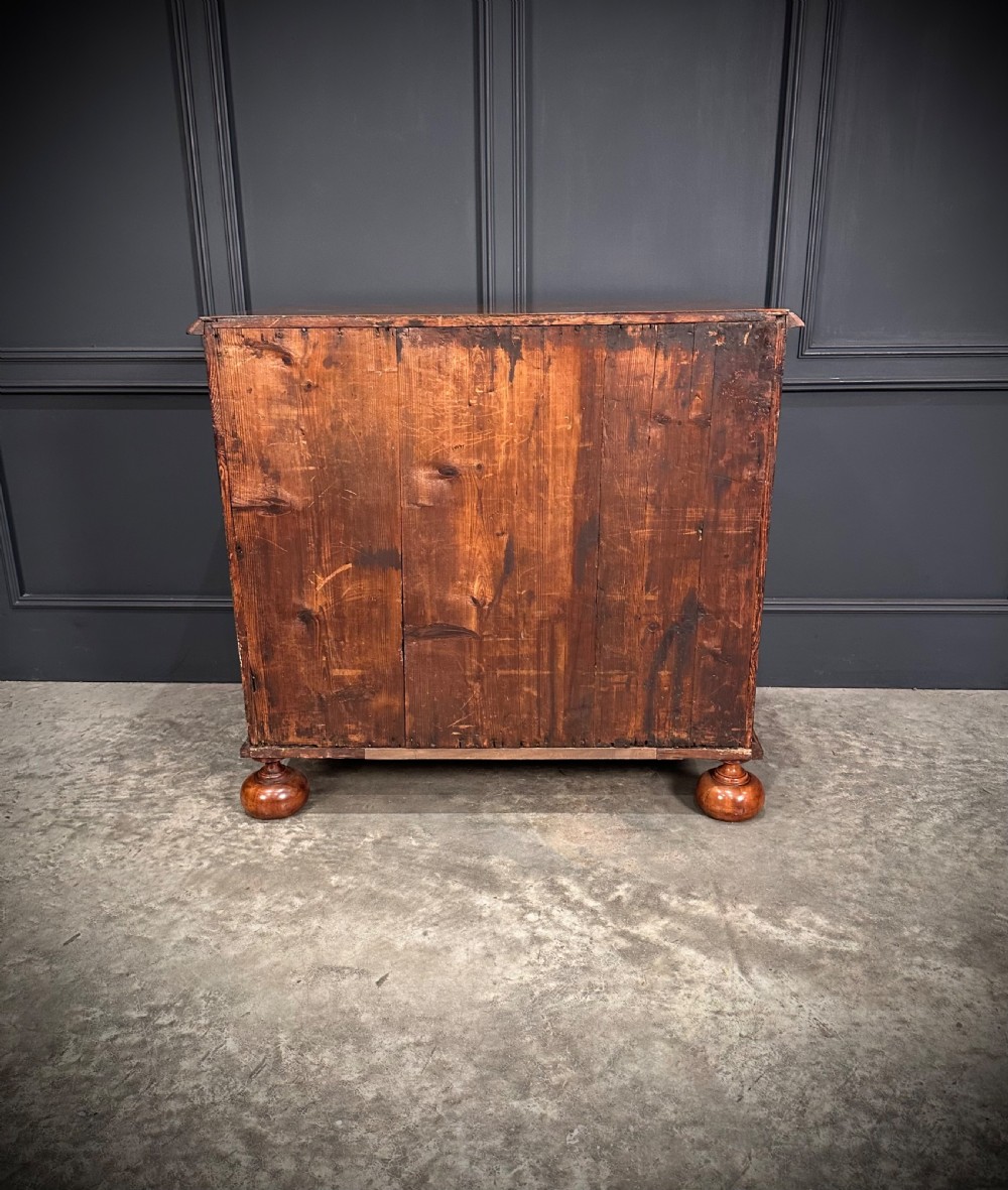 A William and Mary period walnut chest of drawers featuring geometric oyster veneering, brass teardrop handles, and turned bun feet. View XIV