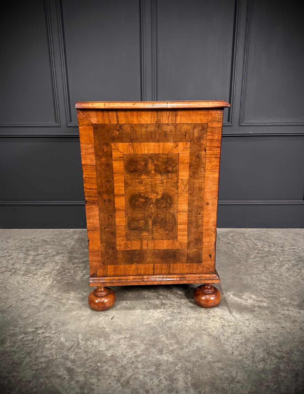 A William and Mary period walnut chest of drawers featuring geometric oyster veneering, brass teardrop handles, and turned bun feet. View XV