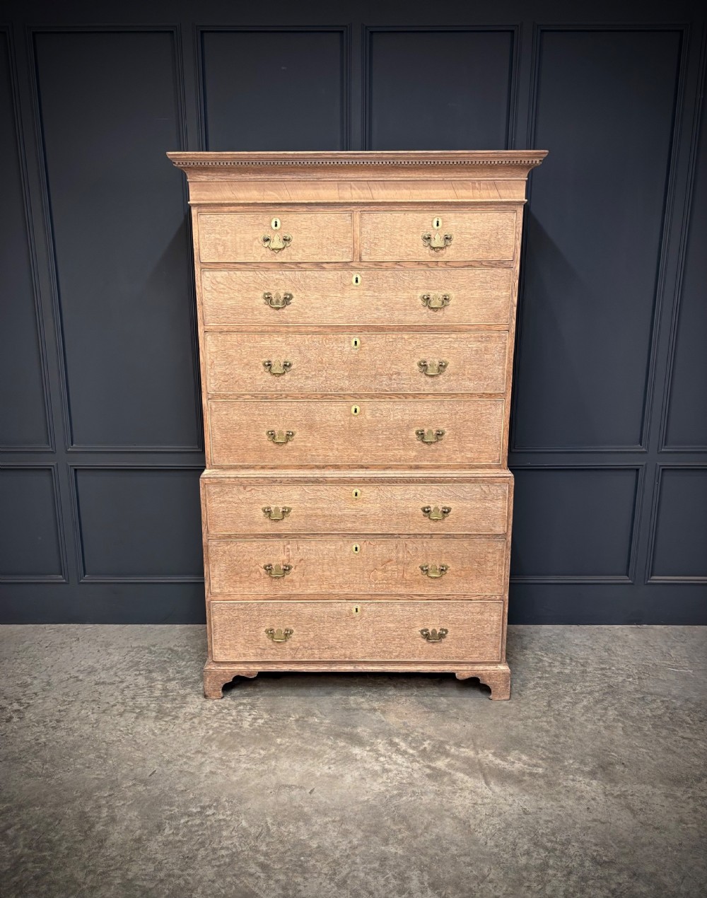 An 18th-century bleached oak chest on chest with stacked upper and lower drawer sections, brass drop handles, and bracket feet. View III