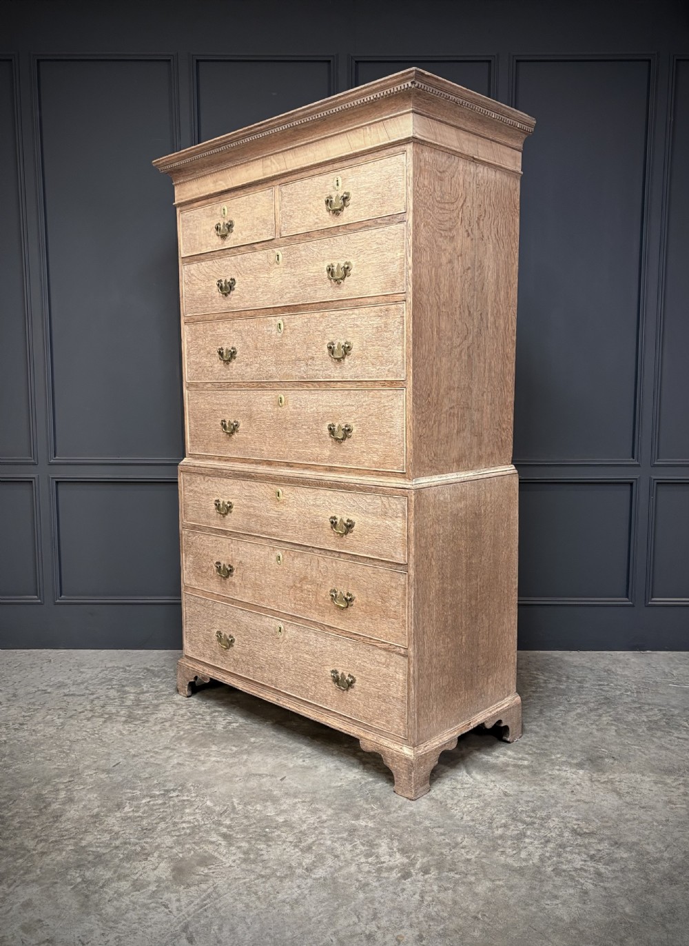 An 18th-century bleached oak chest on chest with stacked upper and lower drawer sections, brass drop handles, and bracket feet. View IV