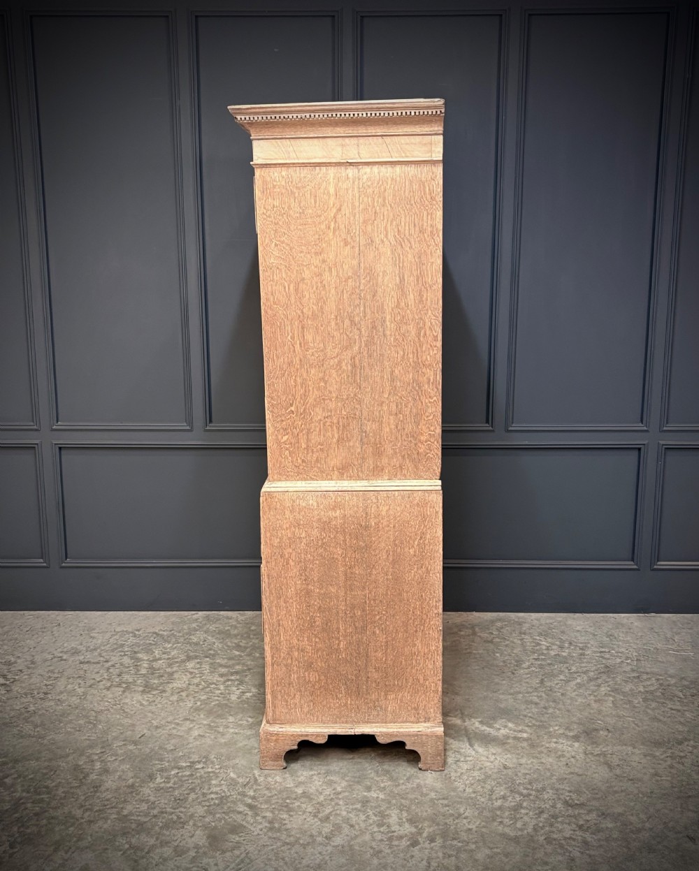 An 18th-century bleached oak chest on chest with stacked upper and lower drawer sections, brass drop handles, and bracket feet. View VI