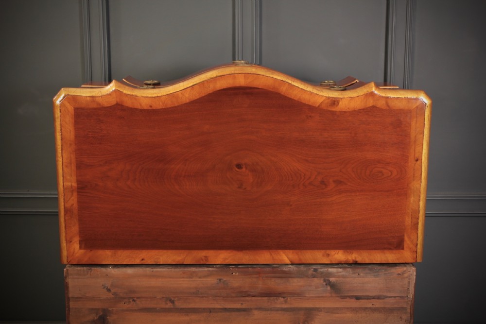 An antique walnut serpentine-front chest featuring four drawers with brass ring pull handles resting on carved cabriole feet. View XI
