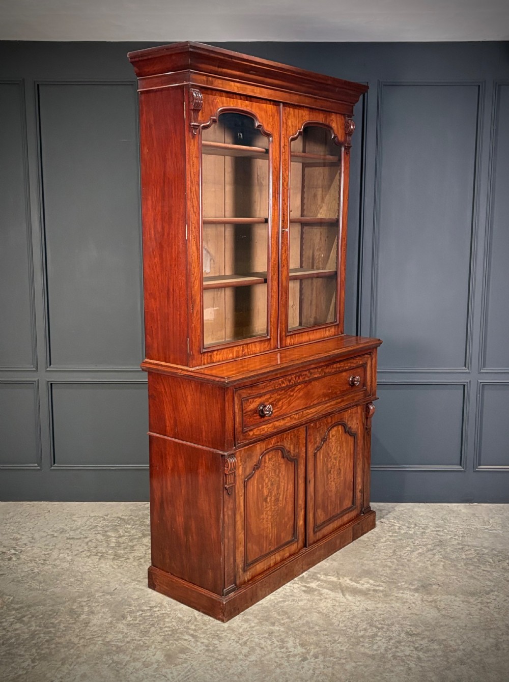 A tall Victorian mahogany secretaire bookcase featuring an upper two-door glazed cabinet over a writing drawer and lower cupboard base.