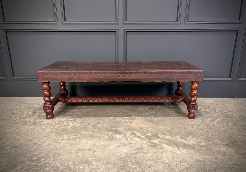 A low rectangular mahogany coffee table featuring three embossed leather top panels depicting heraldic coats of arms and supported by turned legs. View XVI