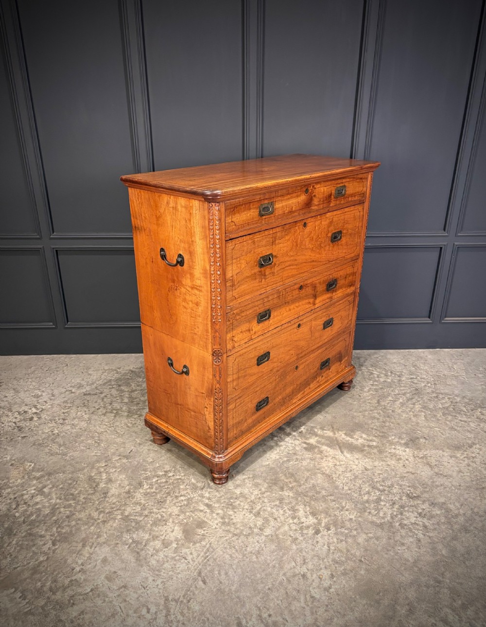 A 19th-century camphor wood campaign secretaire chest featuring a two-part split construction with flush brass handles, side carrying handles, and carved pilasters. View II
