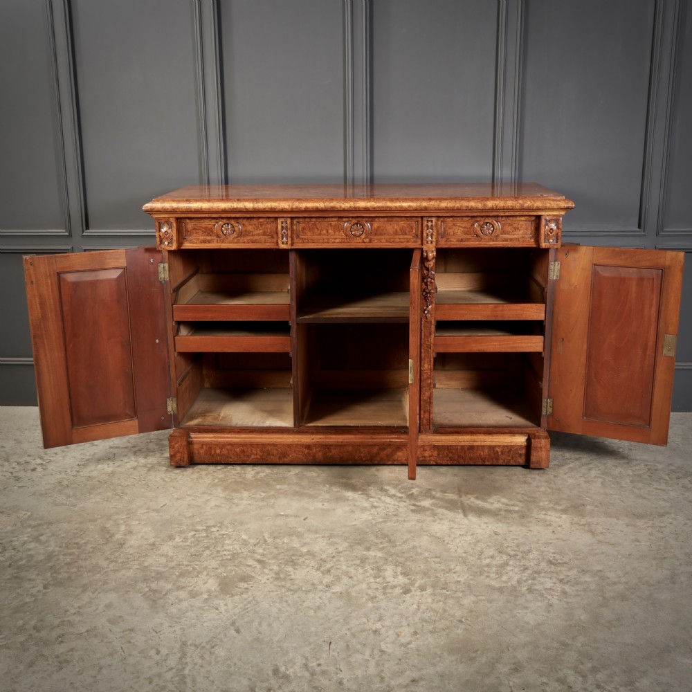 A Victorian pollard oak sideboard featuring three panelled cupboard doors, carved foliage pilasters, and a moulded rectangular top. View V