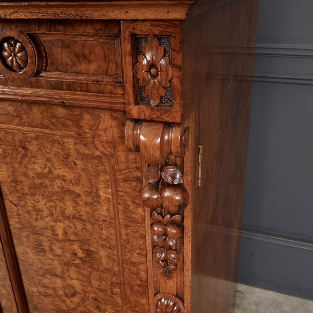 A Victorian pollard oak sideboard featuring three panelled cupboard doors, carved foliage pilasters, and a moulded rectangular top. View VIII